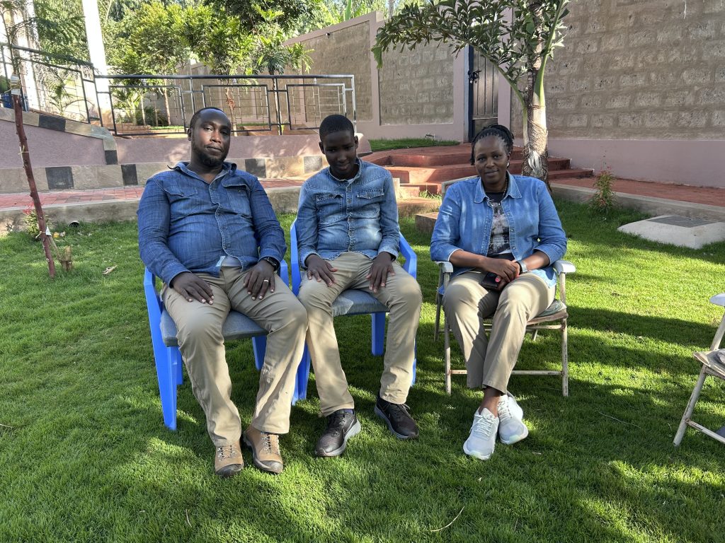 Visitors and staff sitting together outside at the school